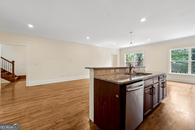 kitchen featuring pendant lighting, sink, light stone counters, a center island with sink, and stainless steel dishwasher