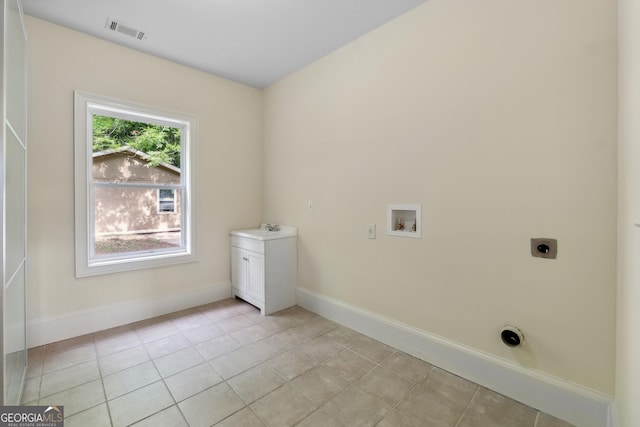 clothes washing area with sink, hookup for a washing machine, hookup for an electric dryer, and light tile patterned floors