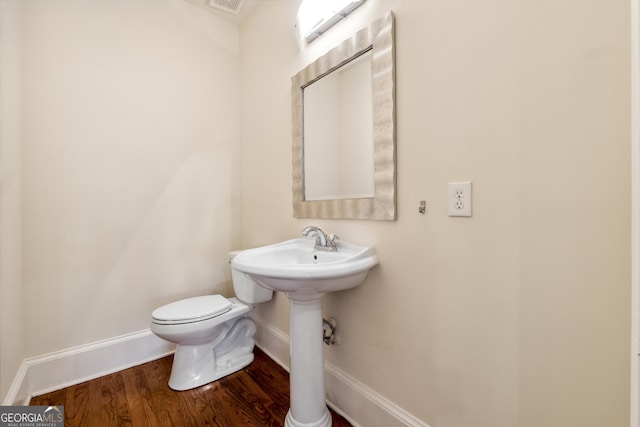 bathroom with hardwood / wood-style flooring and toilet