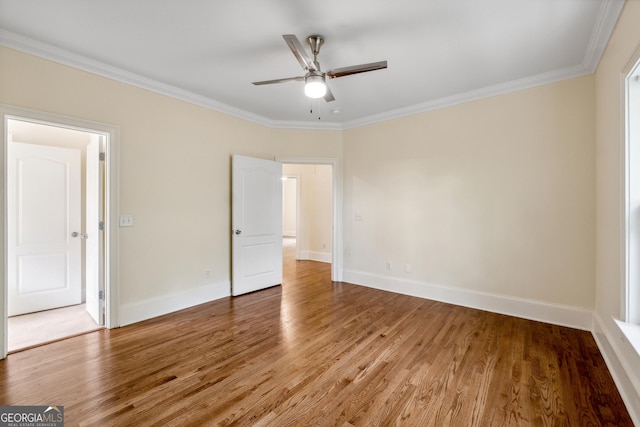 interior space with wood-type flooring, ornamental molding, and ceiling fan