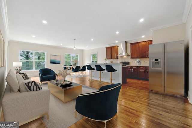 living room with crown molding and light hardwood / wood-style floors