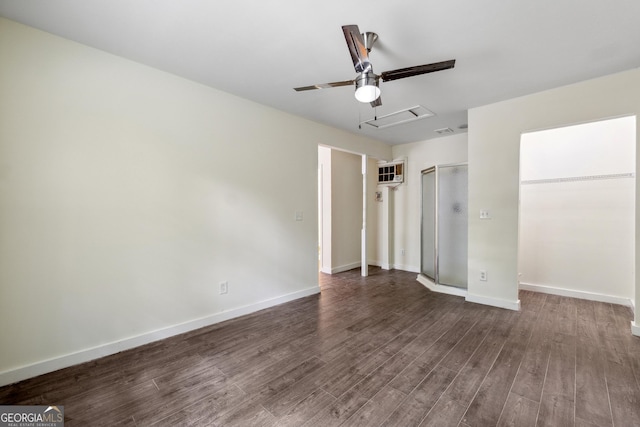 unfurnished bedroom with dark hardwood / wood-style flooring, a wall unit AC, and ceiling fan