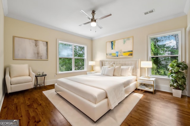 bedroom featuring crown molding, ceiling fan, and dark hardwood / wood-style flooring