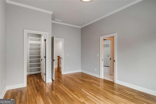 unfurnished bedroom with crown molding, wood-type flooring, and a closet