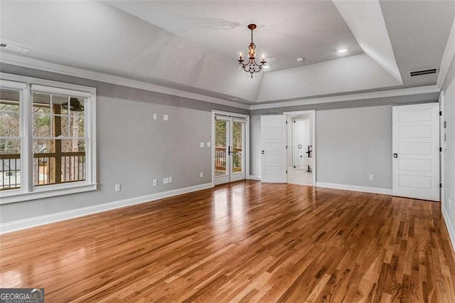 unfurnished living room with hardwood / wood-style flooring, plenty of natural light, and a raised ceiling