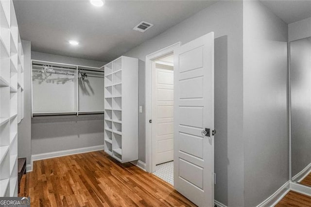 walk in closet with hardwood / wood-style flooring