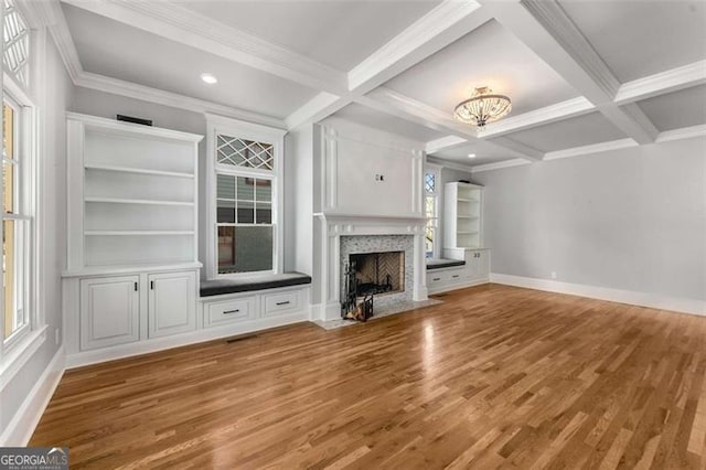 unfurnished living room featuring beamed ceiling, crown molding, hardwood / wood-style flooring, and coffered ceiling