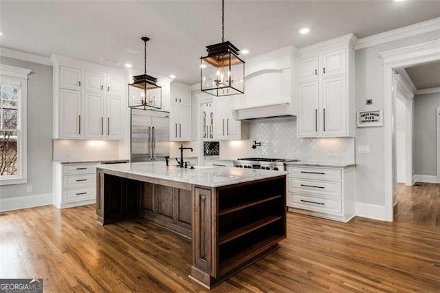 kitchen with white cabinets, sink, an island with sink, and stainless steel built in fridge