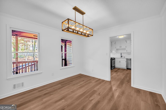 unfurnished dining area with crown molding, a wealth of natural light, and light hardwood / wood-style floors