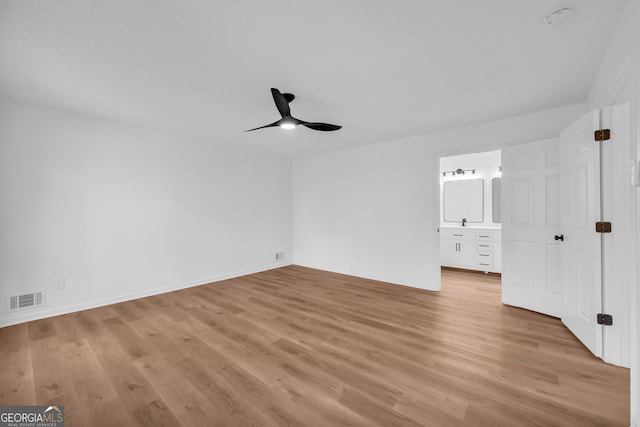 unfurnished bedroom with ensuite bathroom, ceiling fan, and light hardwood / wood-style floors