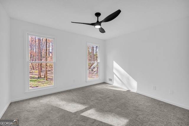 carpeted spare room featuring ceiling fan