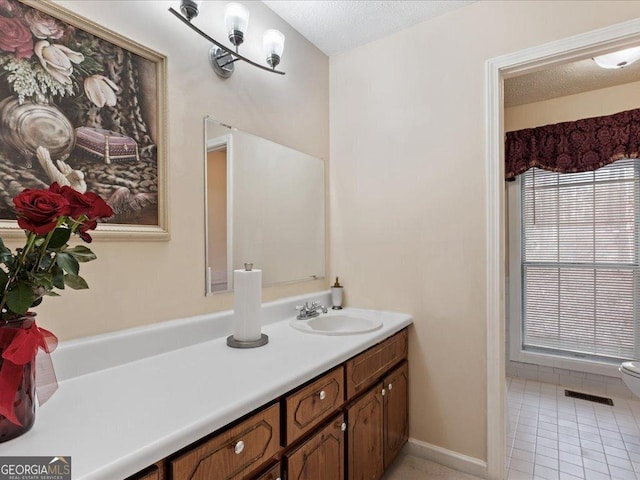 bathroom featuring tile patterned flooring, vanity, and a textured ceiling