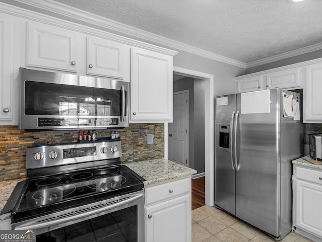 kitchen with white cabinetry, backsplash, and appliances with stainless steel finishes