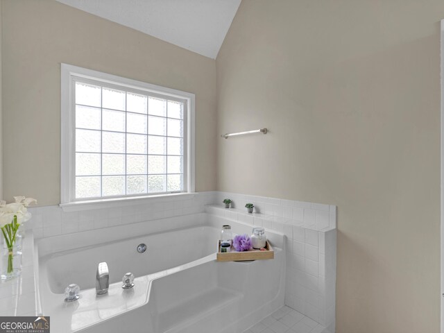 bathroom featuring lofted ceiling and a bathing tub