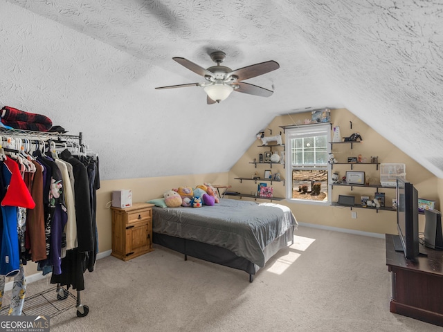 carpeted bedroom with lofted ceiling, a textured ceiling, and ceiling fan