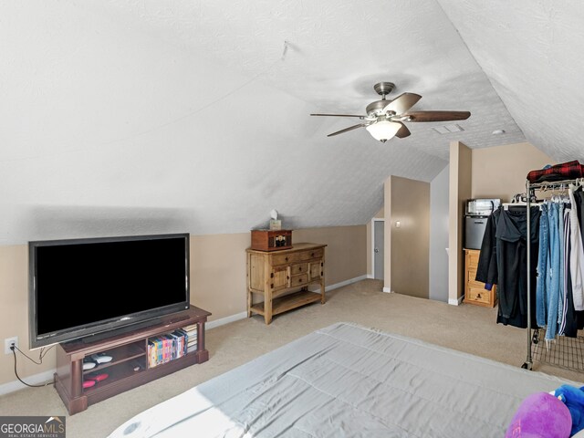 carpeted bedroom featuring a textured ceiling, vaulted ceiling, and ceiling fan