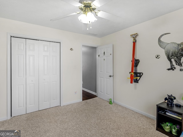 unfurnished bedroom with ceiling fan, carpet floors, and a closet