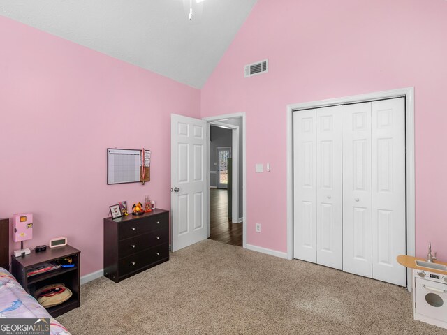 carpeted bedroom with high vaulted ceiling and a closet