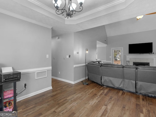 living room featuring crown molding, dark hardwood / wood-style floors, a chandelier, and a textured ceiling