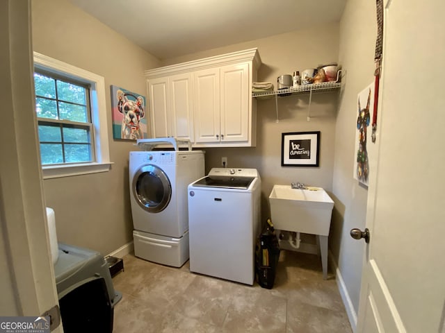 washroom with cabinets, separate washer and dryer, and sink