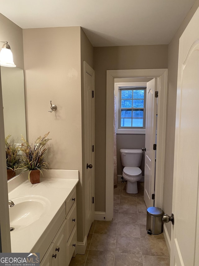 bathroom with vanity, tile patterned floors, and toilet