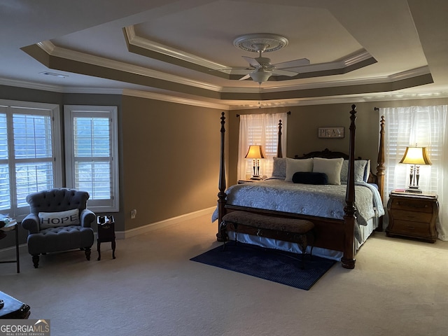 bedroom with crown molding, ceiling fan, a tray ceiling, and light colored carpet