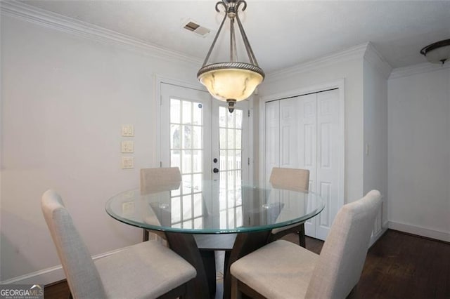 dining room with crown molding, dark wood-type flooring, and french doors