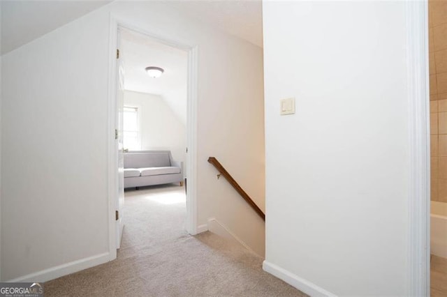 hall featuring light colored carpet and lofted ceiling