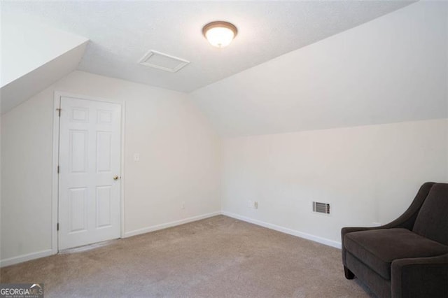 bonus room with lofted ceiling and light carpet