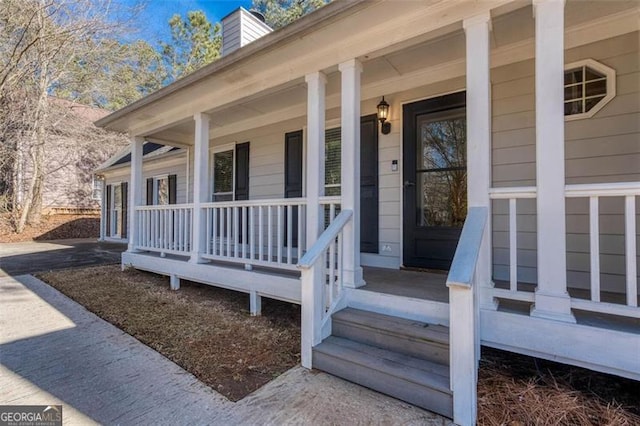 view of exterior entry featuring covered porch