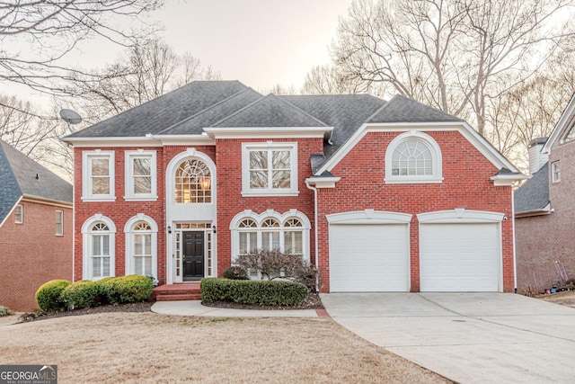 view of front of house with concrete driveway, a garage, brick siding, and roof with shingles