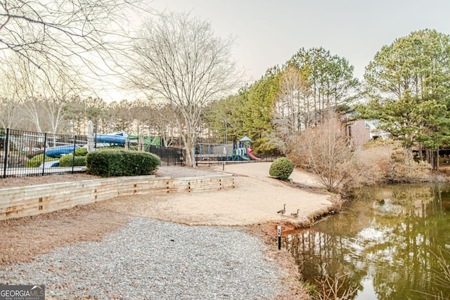 view of yard featuring a playground and a water view