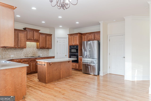 kitchen with black appliances, light wood-type flooring, a kitchen breakfast bar, a kitchen island, and backsplash