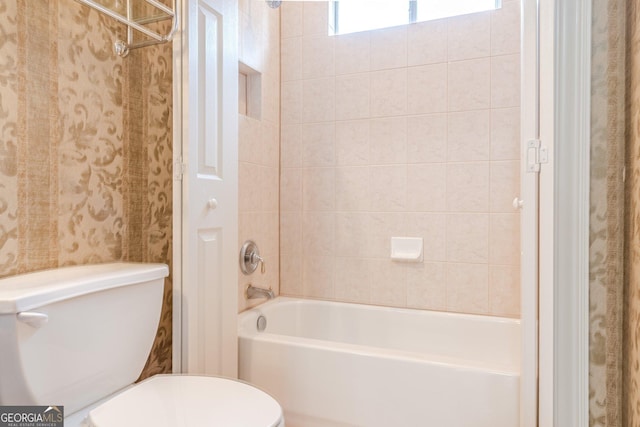 bathroom featuring tiled shower / bath and toilet