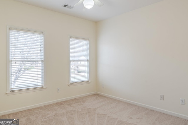 carpeted spare room with ceiling fan