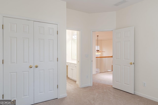 unfurnished bedroom featuring light carpet and a closet