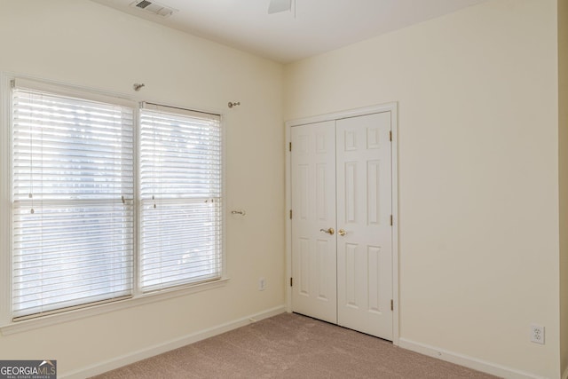 unfurnished bedroom featuring light colored carpet and a closet