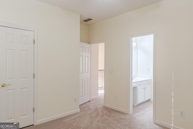 interior space featuring light colored carpet and connected bathroom