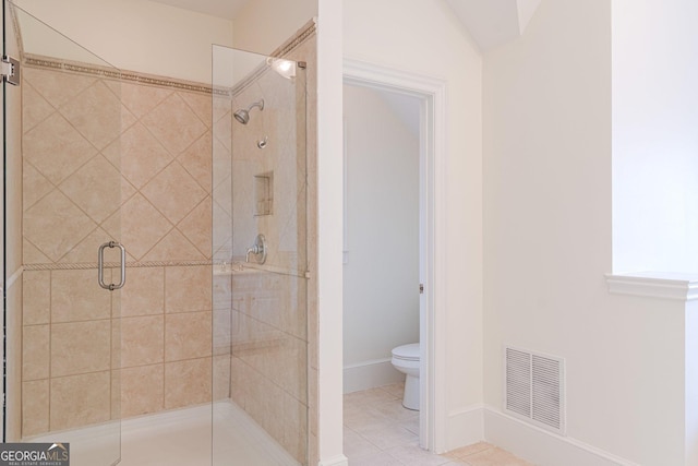 bathroom with tile patterned flooring, an enclosed shower, and toilet