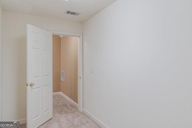 hallway featuring light colored carpet