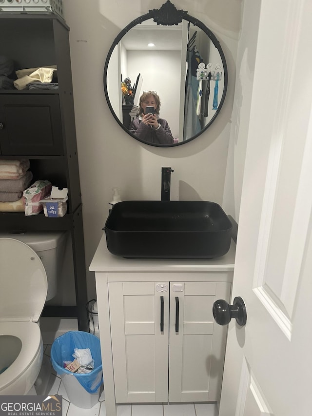 half bath featuring vanity and toilet