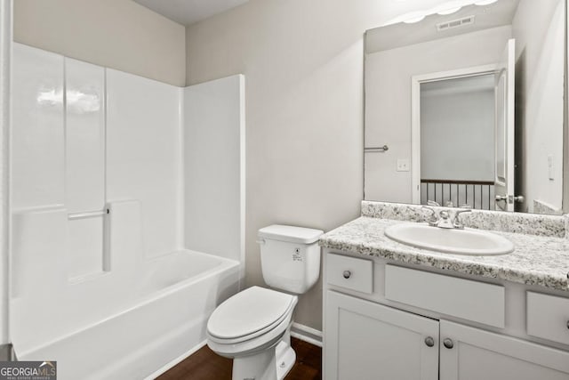 full bathroom with vanity, tub / shower combination, hardwood / wood-style floors, and toilet