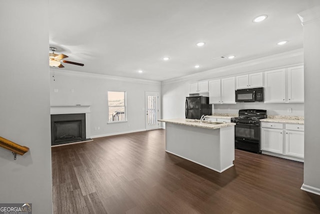 kitchen featuring white cabinetry, ornamental molding, black appliances, and an island with sink