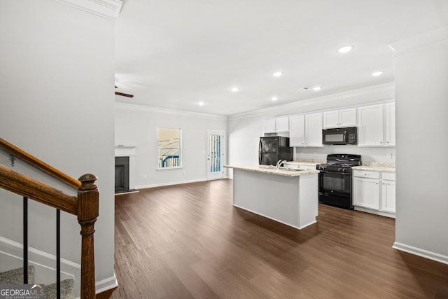 kitchen with white cabinetry, dark hardwood / wood-style flooring, ornamental molding, black appliances, and a center island with sink