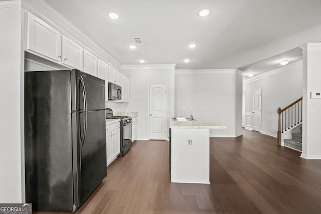 kitchen with sink, light stone counters, black appliances, a center island with sink, and white cabinets