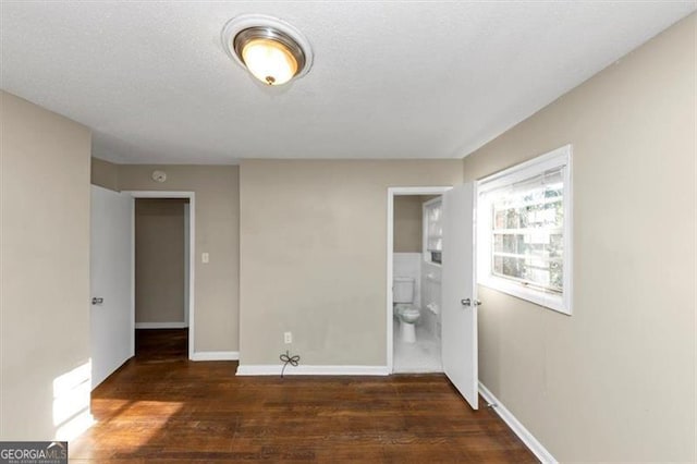 clothes washing area with a textured ceiling and dark hardwood / wood-style flooring