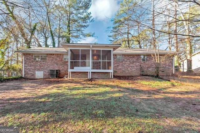 rear view of house featuring central AC, a yard, and a sunroom