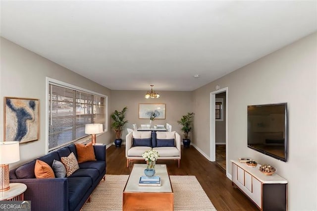 living room with a notable chandelier and dark wood-type flooring