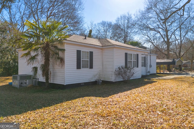 view of side of home with a carport, a yard, and central AC unit