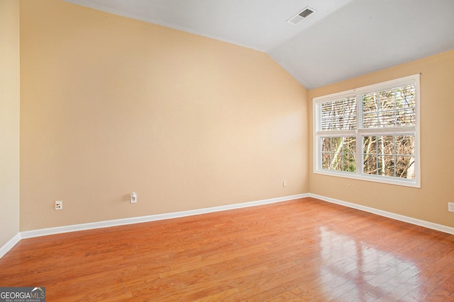 unfurnished room with vaulted ceiling and light hardwood / wood-style floors